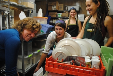 Staff smiling by a dishwasher